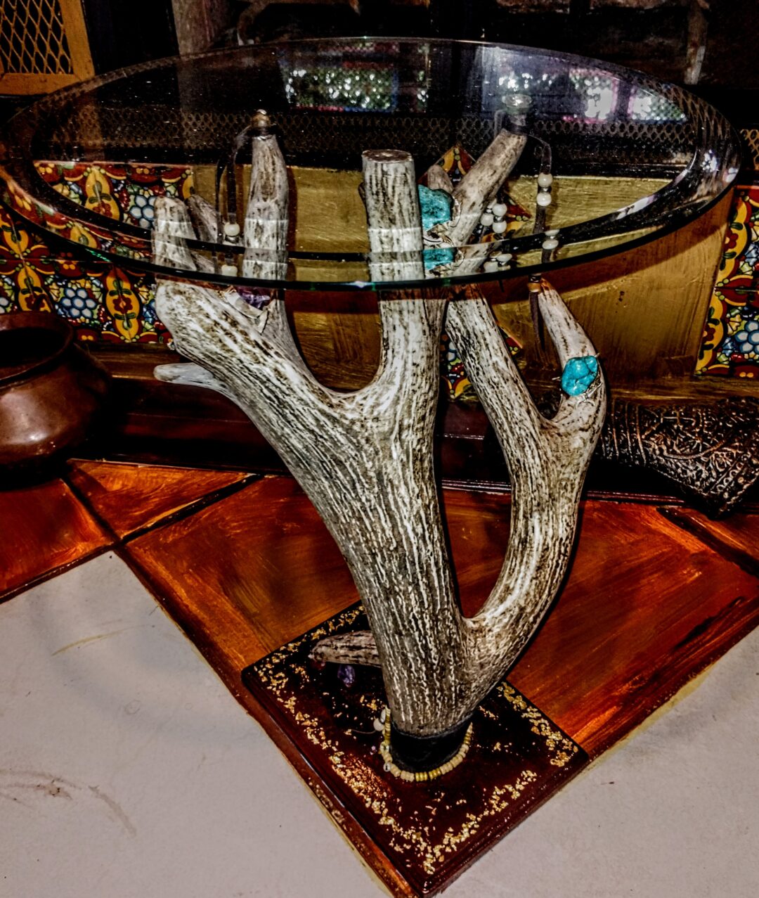 Unique glass table supported by a sculpted hand base with rings.
