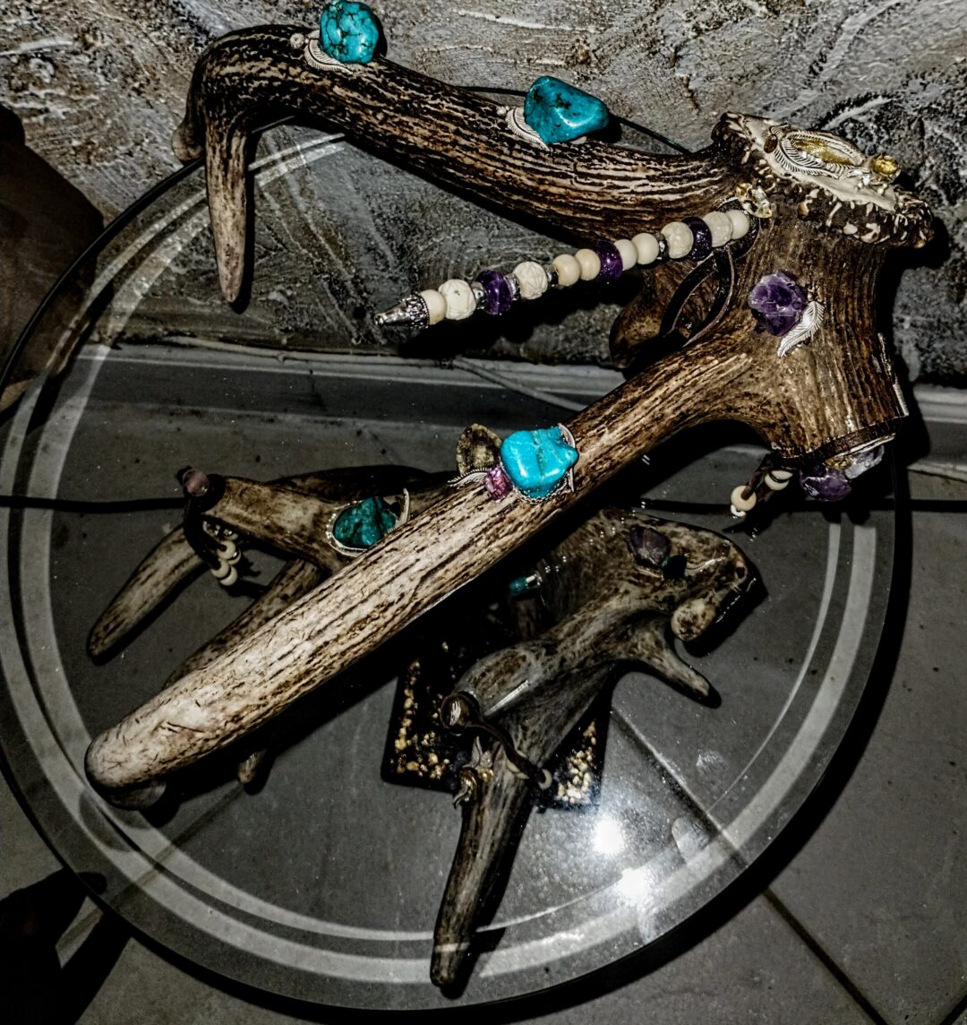 Decorative resin figurines with colorful stones on a glass surface.