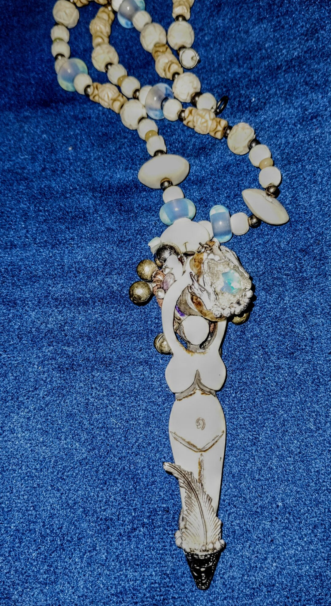 A white floral necklace with a sparkling pendant on a blue background.
